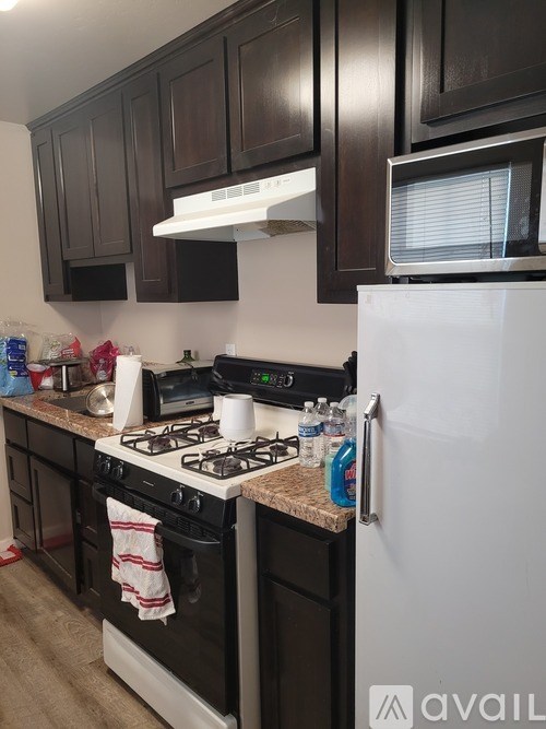 A kitchen with a white stove and black cabinets.