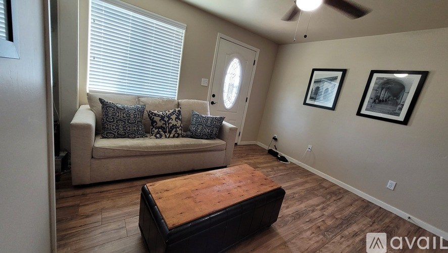 A living room with a couch, a coffee table, and two pictures on the wall.
