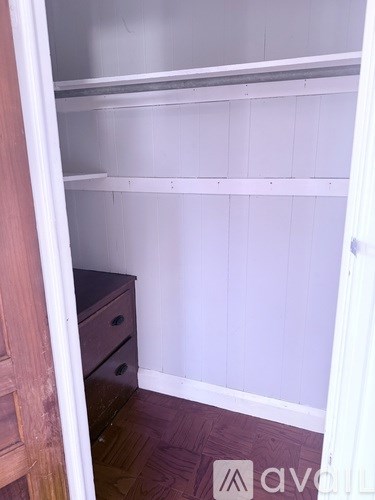 A white refrigerator freezer sits in a kitchen next to a wooden cabinet.