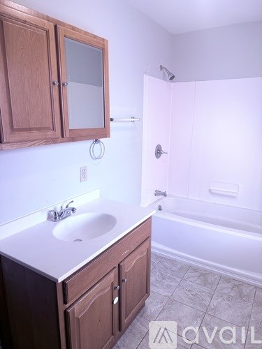 A bathroom with a sink, mirror, and tub.
