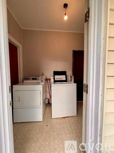 A white fridge and a white cabinet are in a room.
