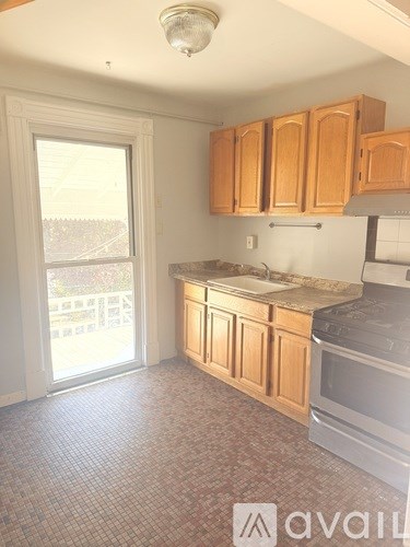 A kitchen with wooden cabinets and a tiled floor.
