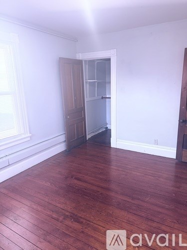 A room with wooden floors and a white wall.