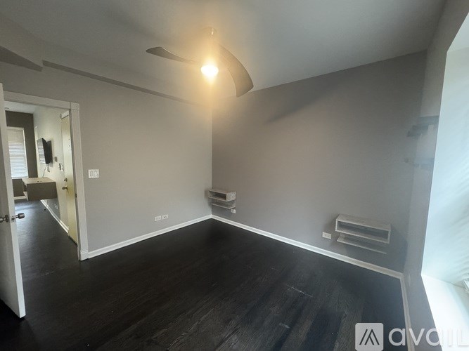 A room with a wooden floor and a white ceiling with a light on.