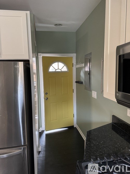 A yellow door with a window in the middle is in a hallway.