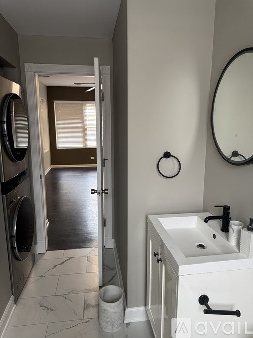 A bathroom with a white sink and a round mirror.
