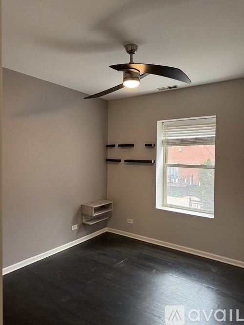 A room with a ceiling fan and a window.