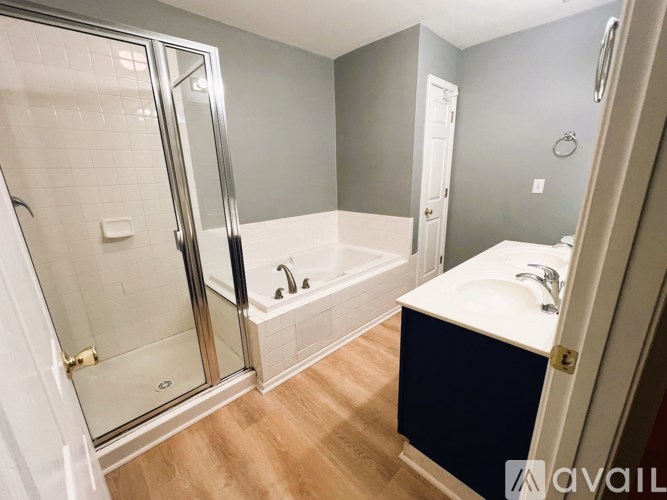 A bathroom with a white sink and a glass shower door.