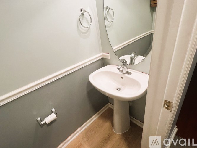 A white pedestal sink in a small bathroom.