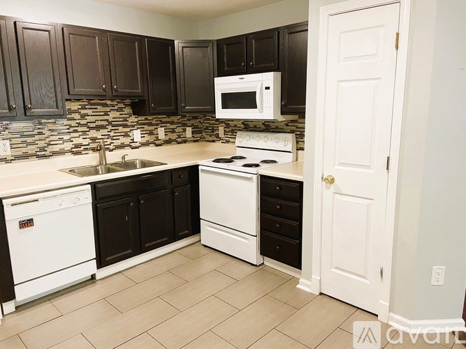 A kitchen with black cabinets and white appliances.