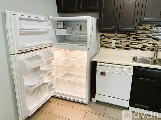 A white refrigerator with its door open in a kitchen.