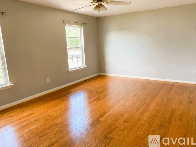 A room with wooden flooring and a ceiling fan.