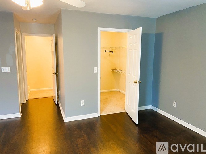 A room with a white door and a wooden floor.