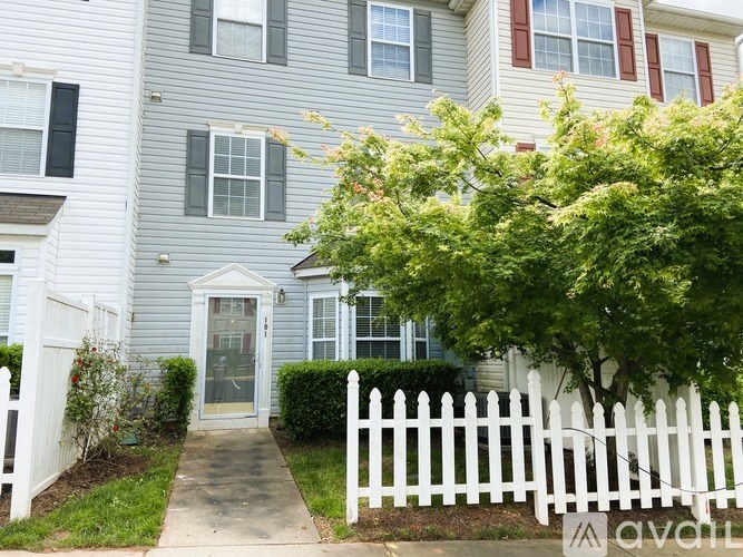 A house with a white picket fence in front.