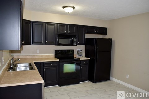 A kitchen with black cabinets and appliances.