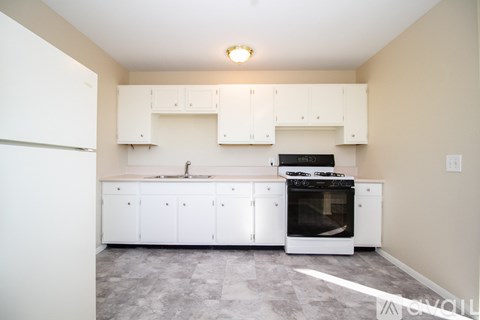 A kitchen with white cabinets and a black stove top oven.