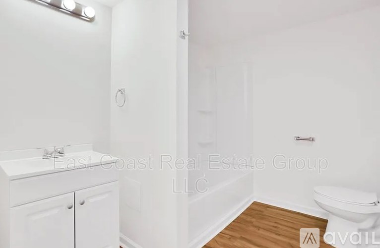 A white bathroom with East Coast Real Estate Group LLC watermark.