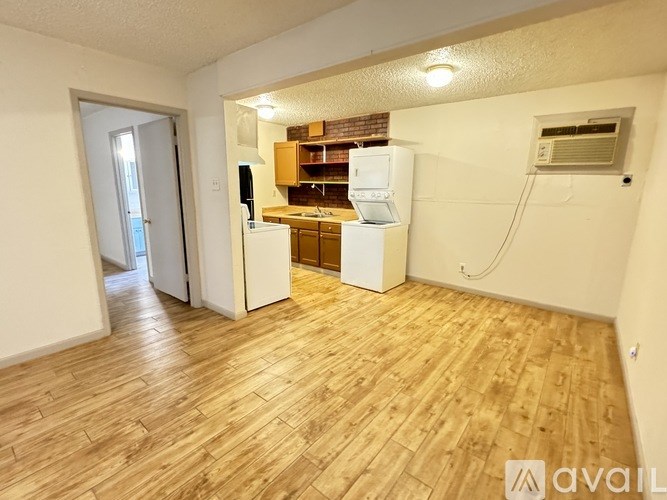 A kitchen area with a refrigerator, cabinets, and a countertop.