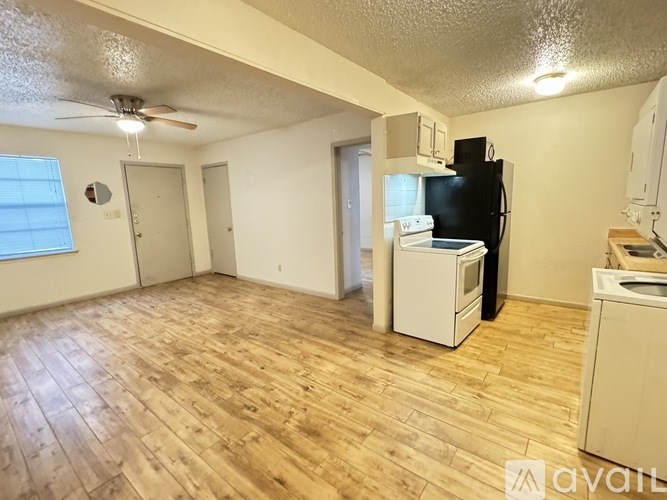 A kitchen area with a refrigerator, oven, and a washing machine.