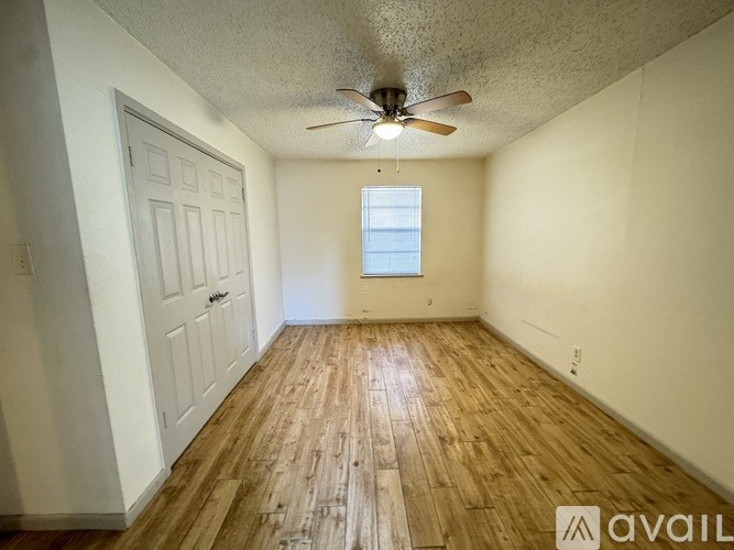 A room with wooden flooring and a ceiling fan.
