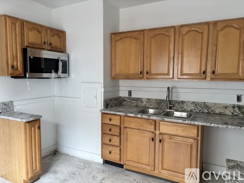 A kitchen with wooden cabinets and a granite countertop.