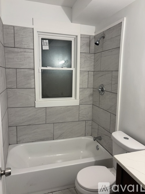 A bathroom with a tub, toilet and sink.