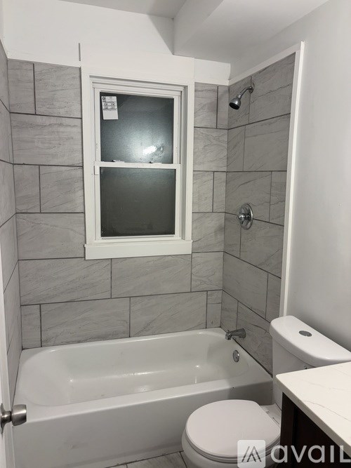 A bathroom with a tub, toilet and sink.