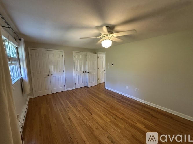 A room with wooden floors and a ceiling fan.