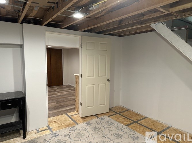 A room with a white door and a rug on the floor.