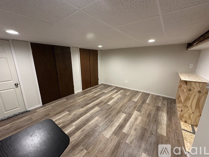 A room with wooden flooring and a black leather chair.