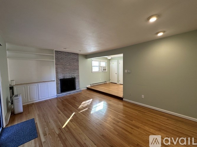 A room with a fireplace and wooden floors.