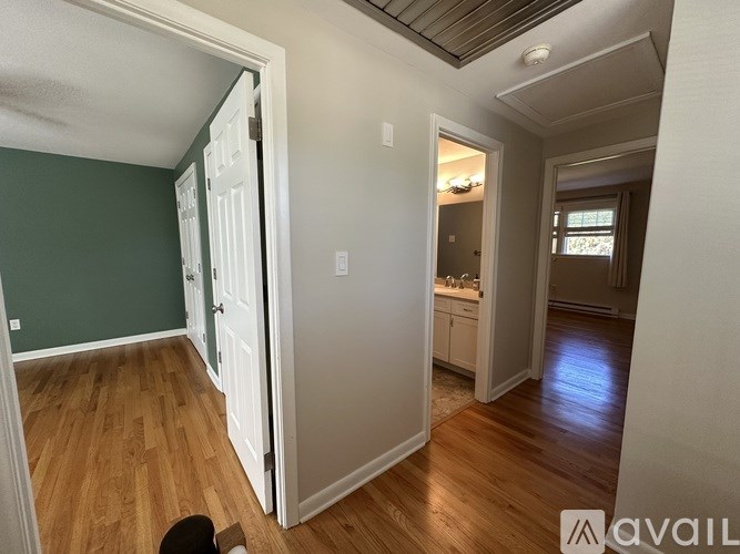 A room with a green wall and wooden flooring.