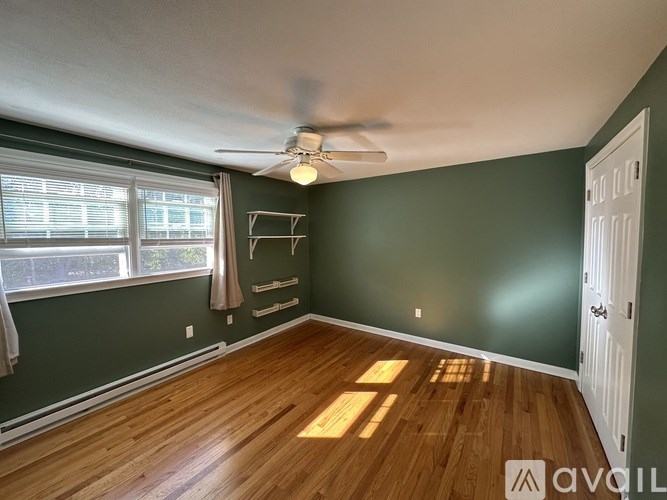 A room with a ceiling fan and a window with blinds.