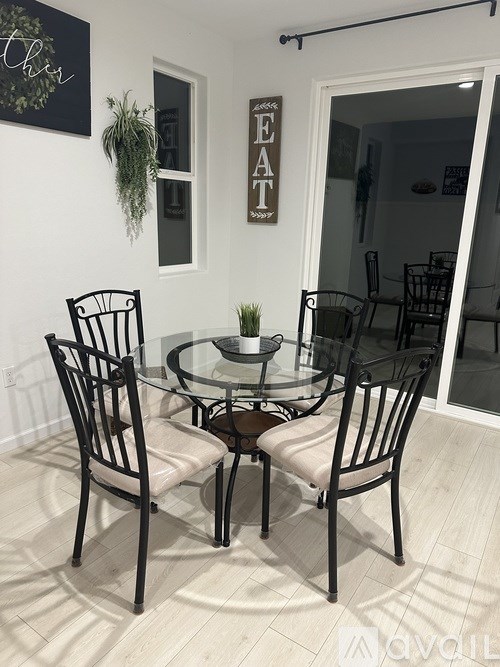 A glass table with four chairs around it.