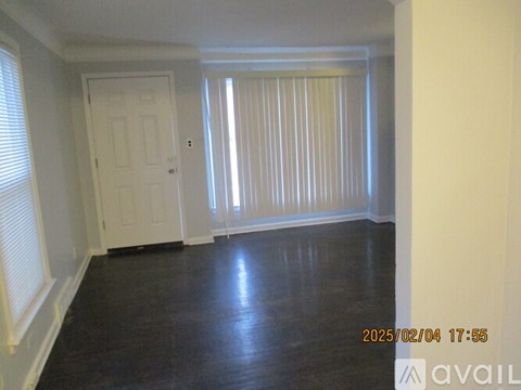 A room with a white door and a window with blinds.