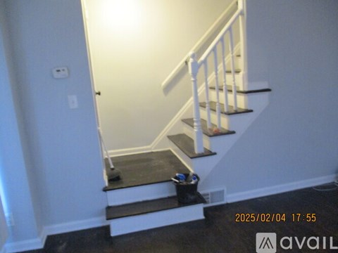 A staircase with a black carpeted step leading to a door.