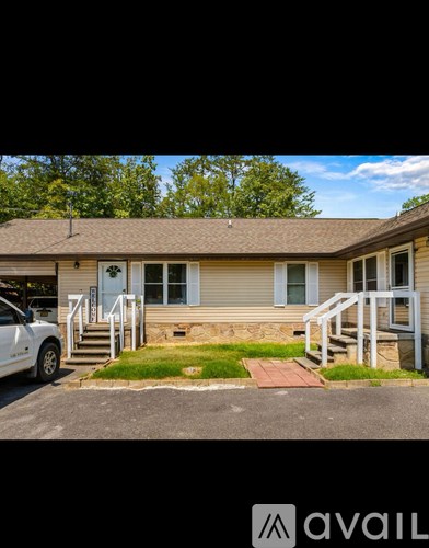 A house with a white car parked in front.