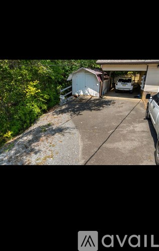 A white car is parked in a driveway next to a garage.