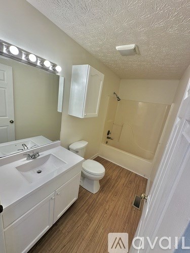 A bathroom with a sink, toilet, and mirror.