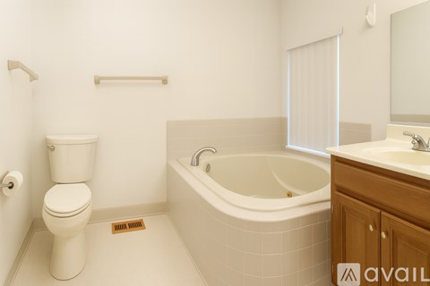 A white toilet sits next to a bathtub in a bathroom.