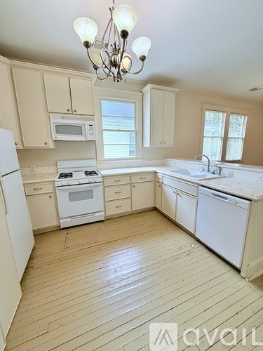 A kitchen with wooden floors and white appliances.