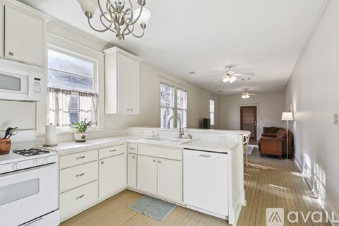 A kitchen with white cabinets and a chandelier.