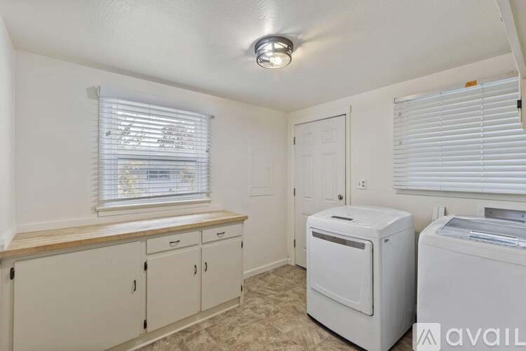 A small room with a window, a printer, and cabinets.