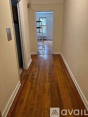 A hallway with wooden floors and white walls.