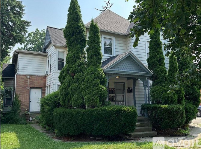 A white house with a grey roof and a grey front door.