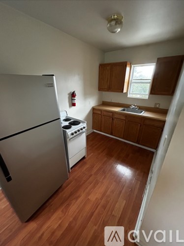 A kitchen with a refrigerator, oven, and cabinets.