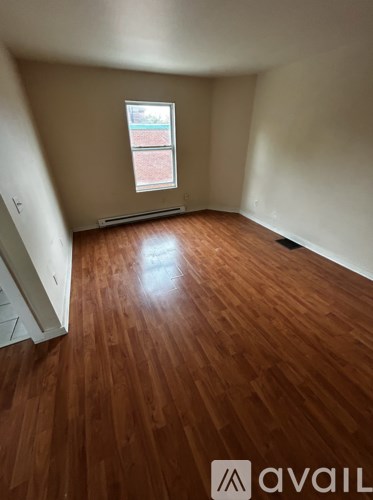 A room with wooden flooring and a window.