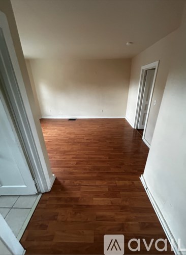 A hallway with wooden floors and white walls.