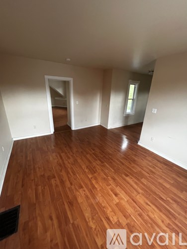 A room with wooden flooring and white walls.
