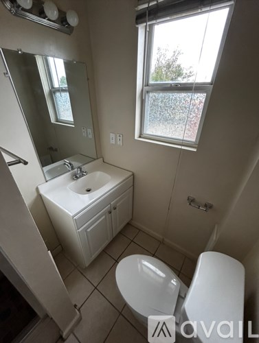 A white toilet and sink in a small bathroom.